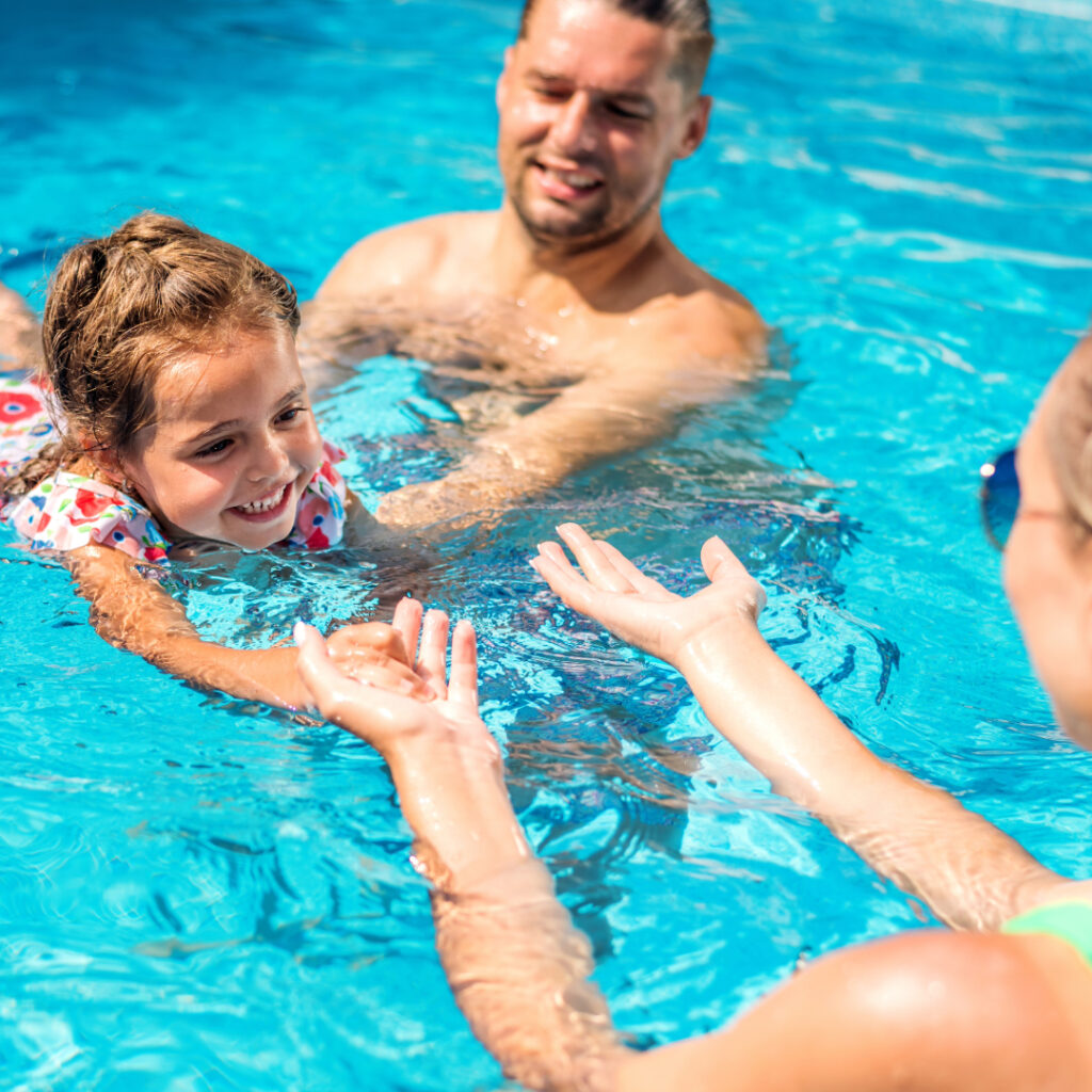 Family enjoying heated pool from a solar thermal solution.